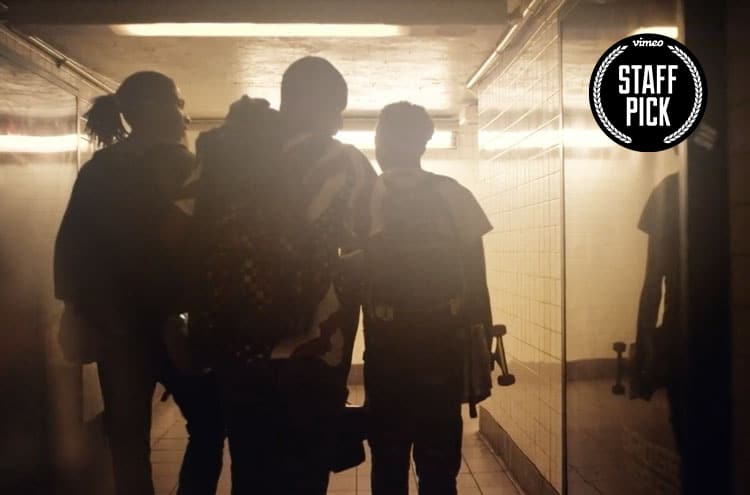 Silhouette of a group of guys walking in a hallway.